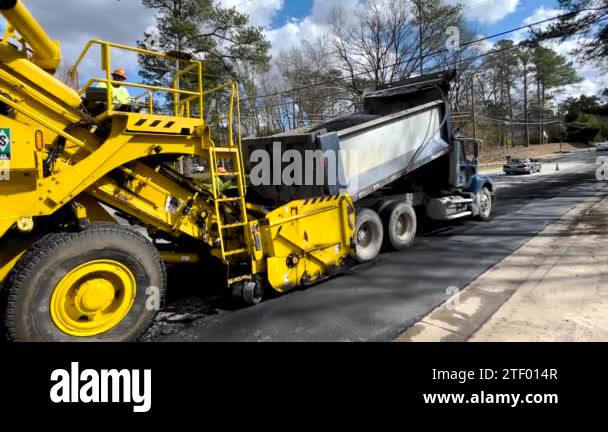 Augusta, Ga USA - 02 16 22: Road paving crew dump truck dumping a full ...