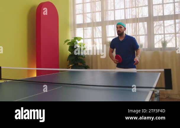 Good looking guy playing on the ping pong game he catch the balls and
