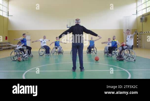 the selector of the basketball team with a disability stands in front ...