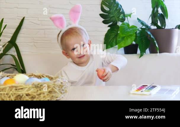 Funny happy child boy with easter eggs and bunny ears dancing. Easter