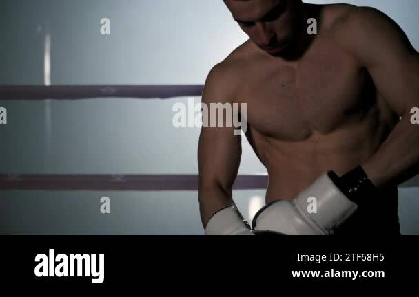Boxer puts on boxing gloves. Male fighter putting his gloves on ...