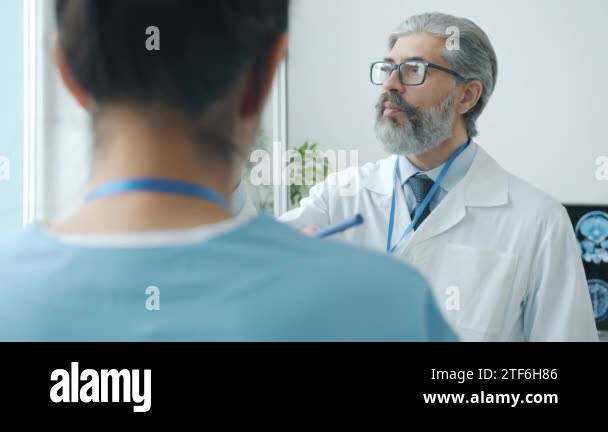 Neurologist analyzing brain scans discussing MRI images with female ...