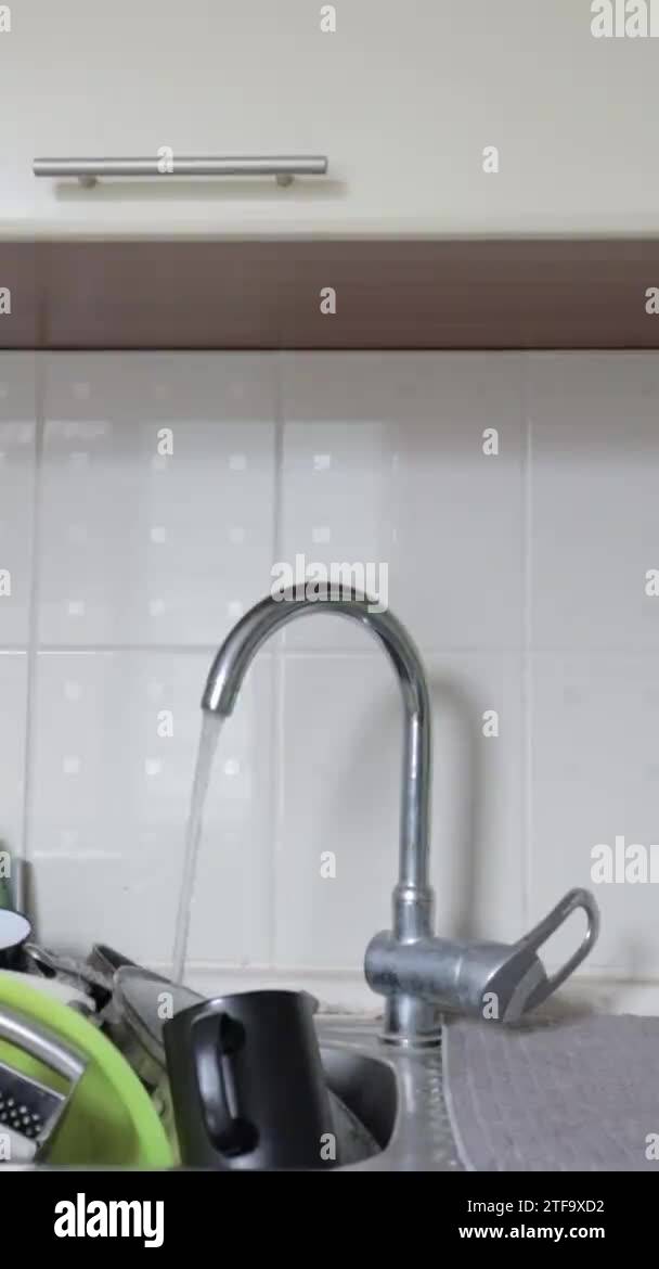 Kitchen utensils in the washbasin must be washed. vertical video. A