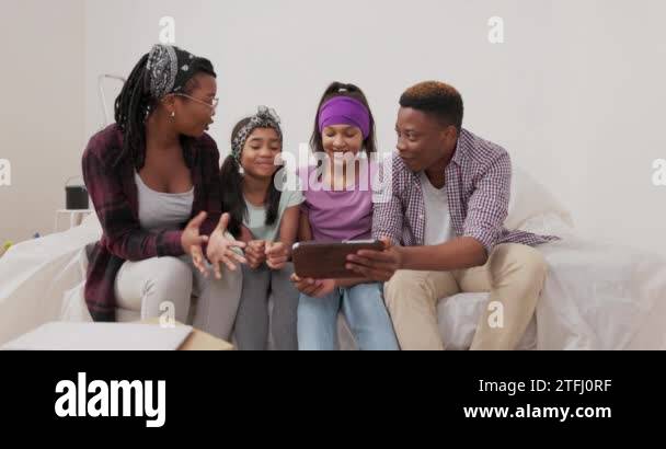 A happy family sits on couch in apartment during renovation married ...