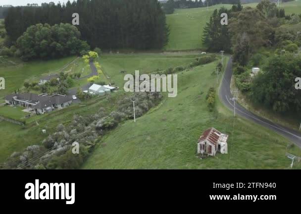 aerial view of car driving in a rural area with houses in new zealand ...