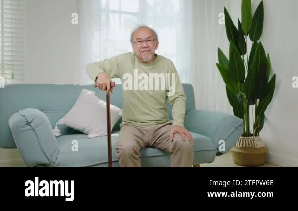 Elderly man suffering from knee pain ache holding handle of cane ...