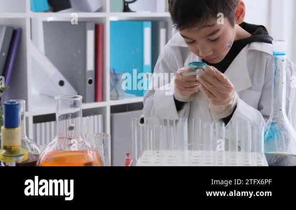 Schoolboy at chemistry lesson looking on test results through ...