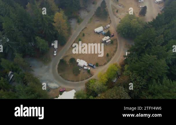 Top down view of campground in the forest with lonely cars and empty ...