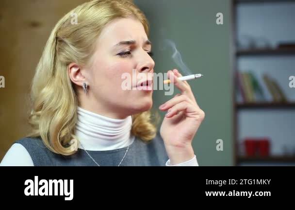 Blond woman smoking cigarette, coughing and drinking glass of wine. Bad habits