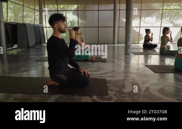 Side view of group of people doing breathing exercises at the yoga ...