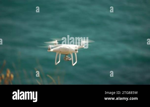 White drone flies against the backdrop of the sea of nature. Drone ...