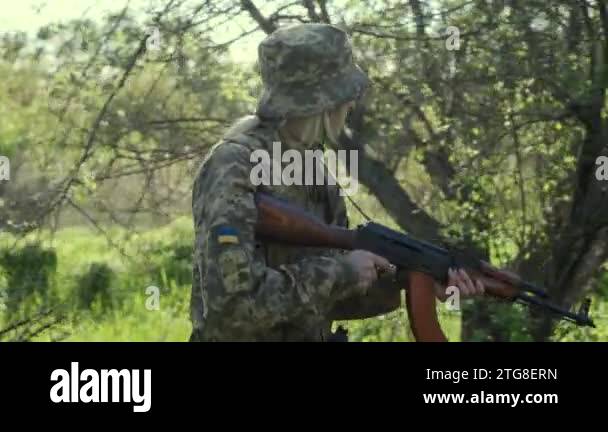 Ukrainian female soldier armed with an assault rifle patrols a combat ...