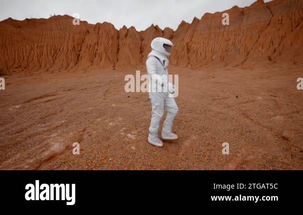 The astronaut walks on the surface of an uninhabited planet in a ...
