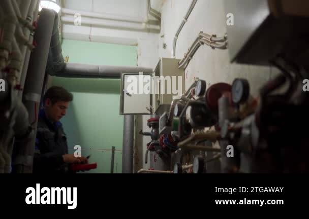 Electrician inspecting control panel with multimeter in a district ...