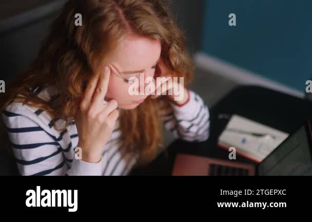 Overworked woman works with laptop at home, massaging temples suffering ...