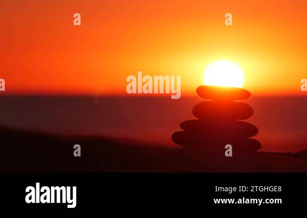 Sun Rising Stack Stack of pebble stones, sandy ocean beach, sunset sky. Rock balancing ...
