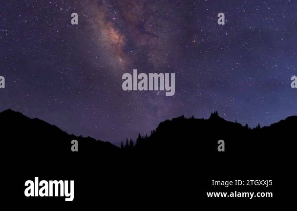 Night time lapse. The Milky Way Galaxy moving over the mountain ridge ...