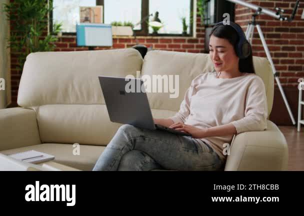 Smiling heartily student attending online class on laptop while sitting ...