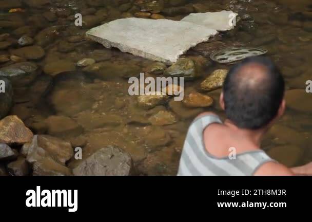 Pohnpei, Micronesia - July 23, 22: Old man is feeding a giant eel. Old