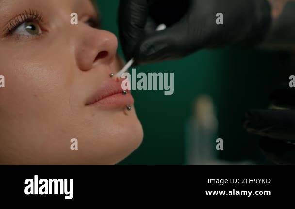 Woman became ill after lip piercing, tattoo parlor. Woman sniffing ...