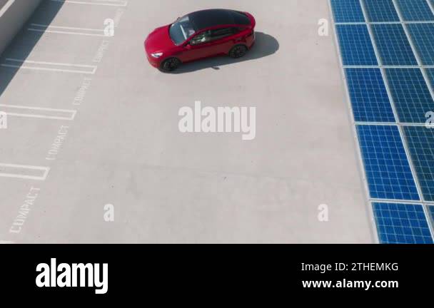 Generic red electric car parking at electric vehicle charging station ...