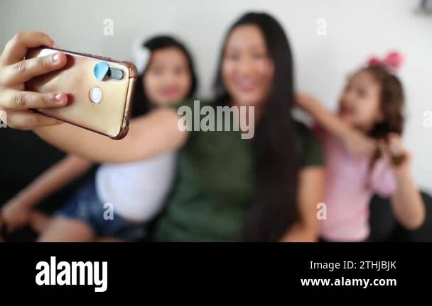 Family speaking on video call using cellphone. Asian mother with little ...