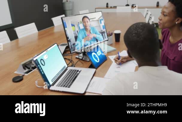 Diverse businesswomen in office using computer with video call and ai ...