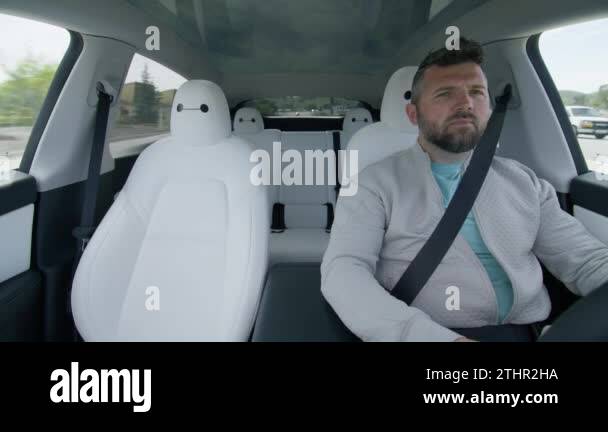 Mature male driver inside Tesla Model Y car using self drive autopilot ...