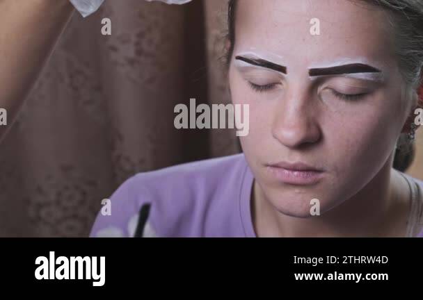 Building the shape of the eyebrows. Beauty salon. Eyebrow master dyes ...