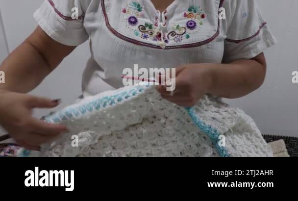 Female adult hands knitting the interlocking blue and white colors ...
