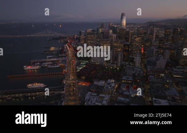 Fly above metropolis at dusk. Aerial footage of coastal road and piers ...