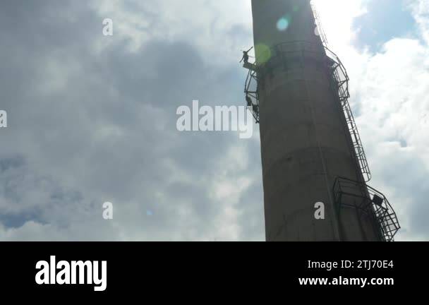 Man jumping with rope from base on big and tall chimney pipe. Free ...