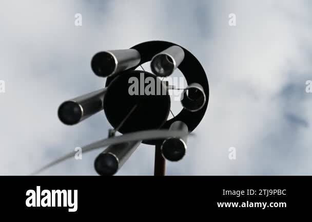 Looking up to the sky underneath a spinning wind chime as the bars are ...