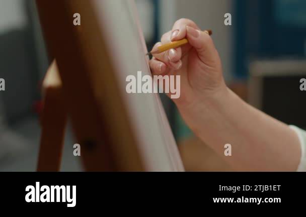 Female artist holding pencil to draw vase outline sketch on canvas ...