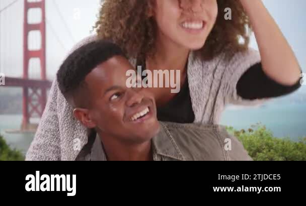 Young black couple flirting by the Golden Gate Bridge. Millennial ...