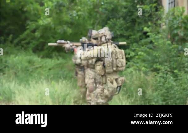 Smart teamwork of soldiers walking forward and attacking enemy during ...