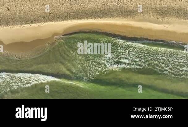 Static top down view of tropical beach, foamy ocean waves washing sand ...