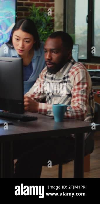 Vertical video: Creative agency employees using computers to develop ...