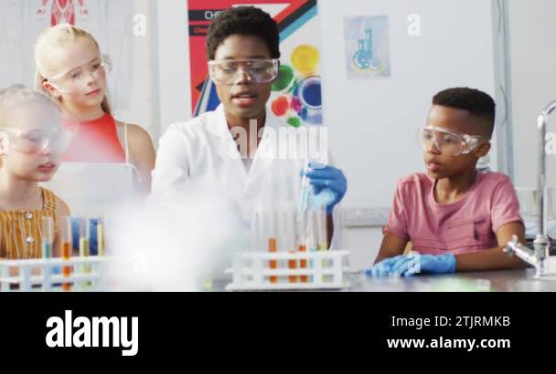 Diverse female teacher and happy schoolchildren having science class in ...