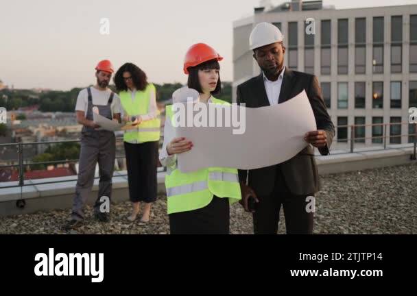 Fresh Look at Diverse Team Of Specialists Holding Structural Layouts In Hands And