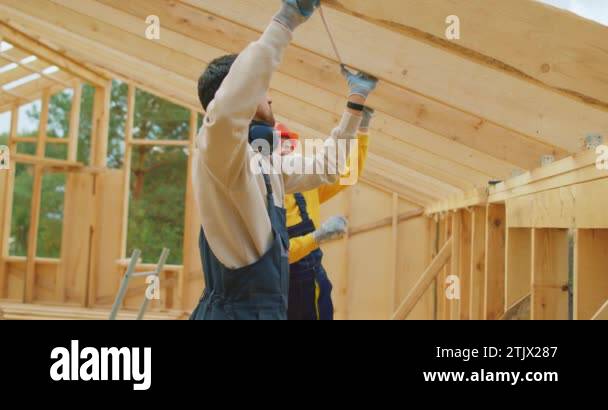 Builders Using Measure team of man and woman builders in work uniform and hardhat using ...