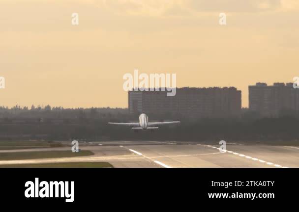 Plane Taking Off Rear View Long shot, jet passenger plane taking off. Rear view of a silhouette of ...