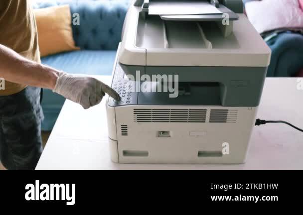 printer repair technician. A male handyman inspects a printer before ...
