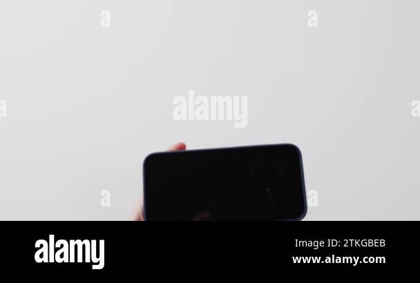 Video of caucasian woman's hand holding smartphone with blank screen on ...