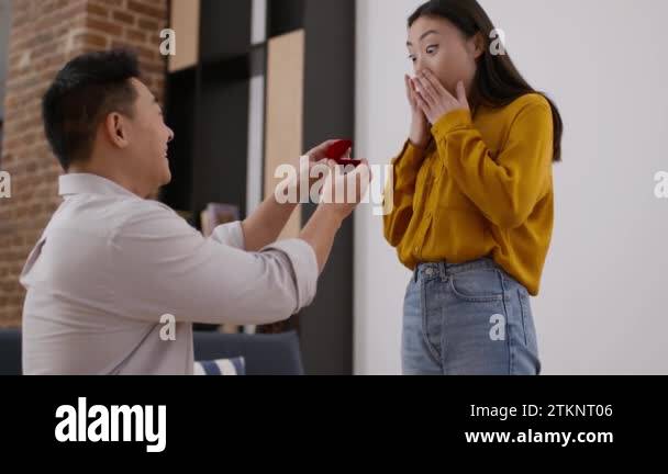 Creating new family. Young excited asian woman getting proposal from ...