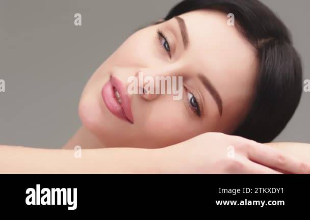 Young healthy brunette woman smile and touching smooth skin on face ...