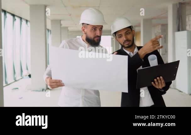 Pretty architect is explaining to Arab builders the plan of ...