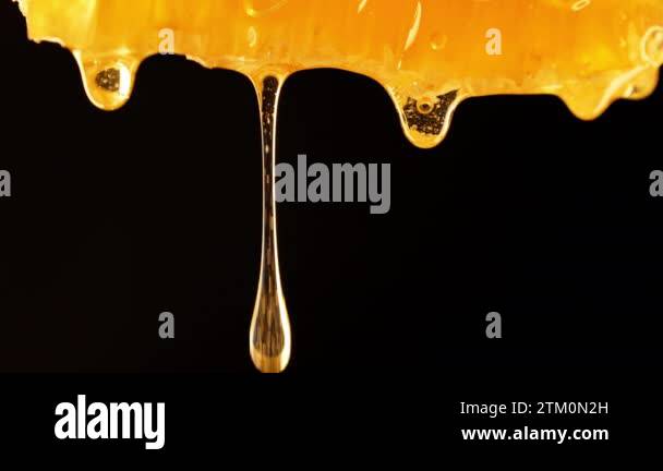 Golden elegance unveiled: enchanting macro footage of honey dripping in ...