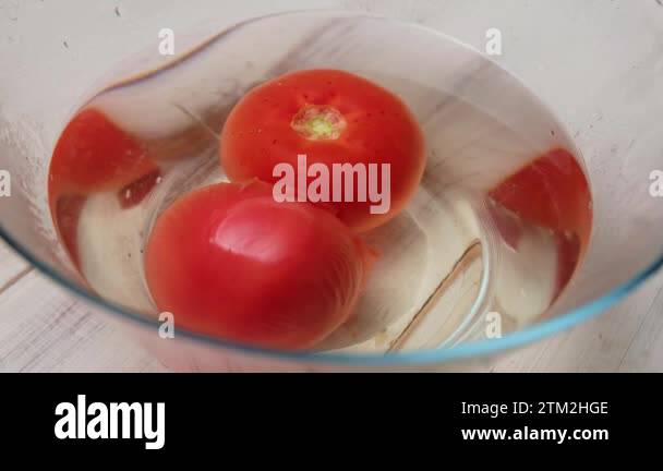 Peeling the peel of a tomato. Two tomatoes in boiling water in a deep