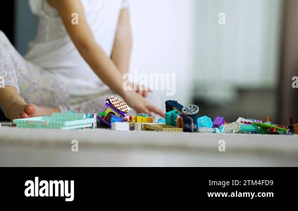 Close up view of little girl playing with small constructor toy on the ...